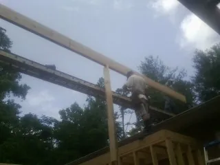 Carpenter setting a ridge beam over a new addition frame — Ice Dam Removal by Roofing Brothers in Knierim