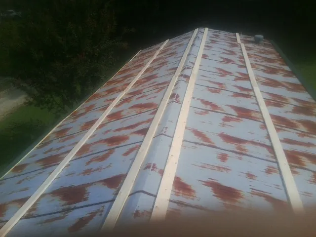 Rusted metal roof panels with new wood purlins before replacement — Storm Damage Roof Repair in Knierim by Roofing Brothers