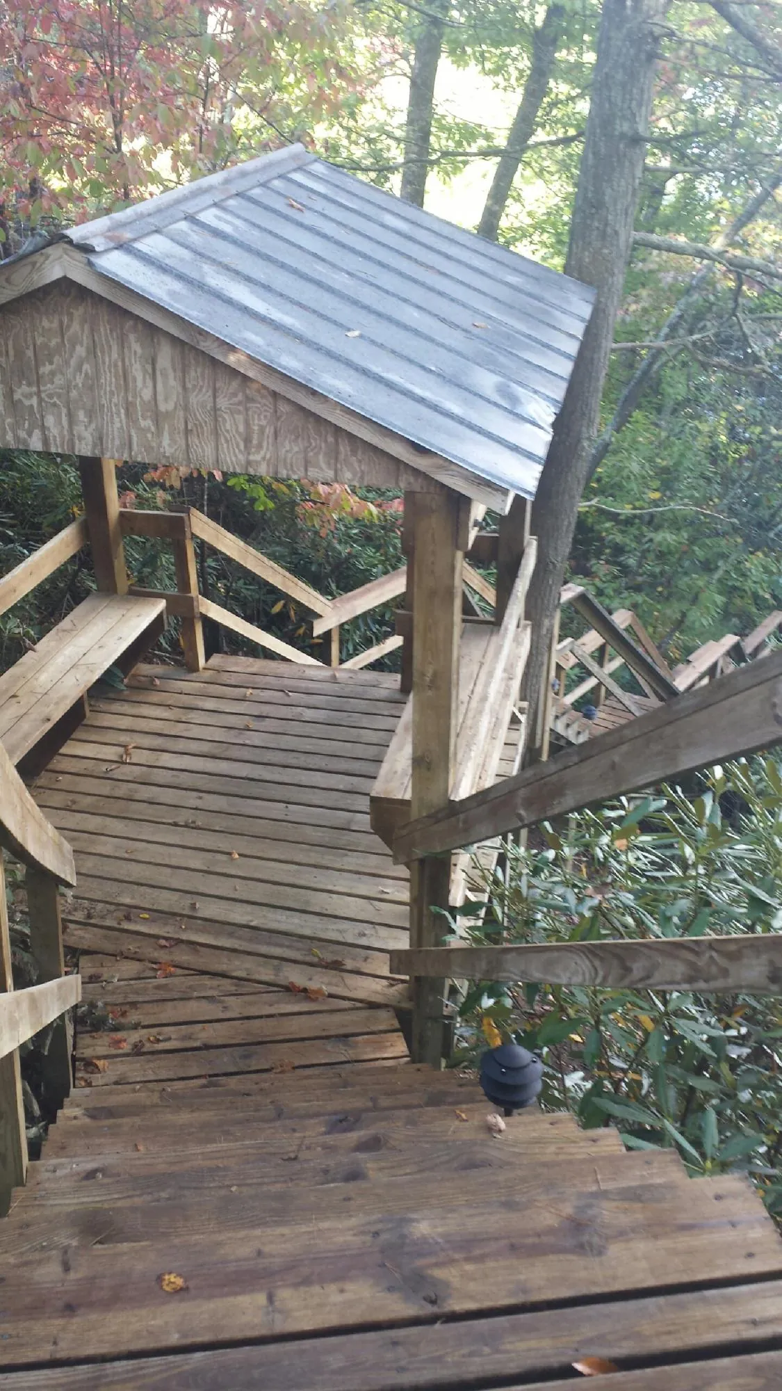 Metal roofed shelter over wooden steps on a wooded walkway — Skylight Repair & Installation work by our crew in Knierim