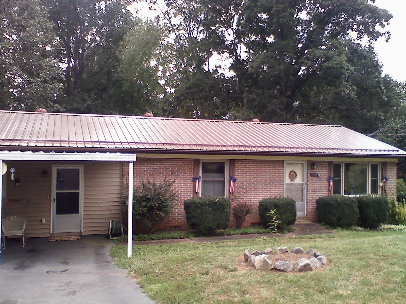 Bronze metal roof and carport on a brick ranch home — Roof Repair work by our crew in Knierim